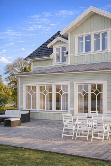 Allmogefönster i trä i vacker grön fasad